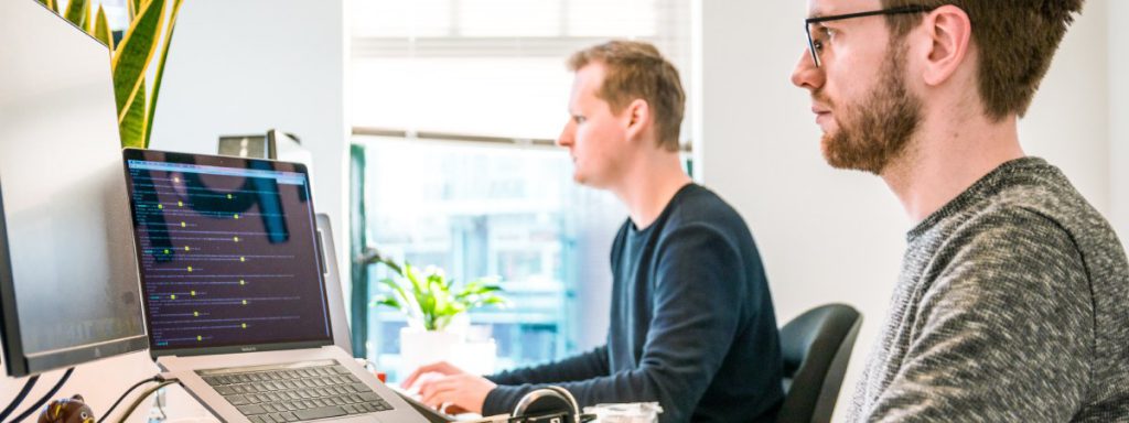 Bilden visar tvÃ¥ killar som arbetar vid sin dator