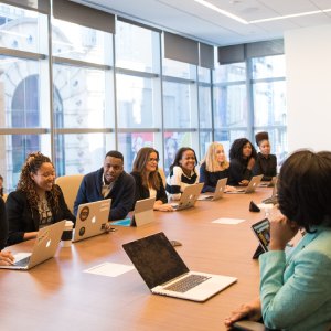 Bilden visar ett konferensbord med många personer kring